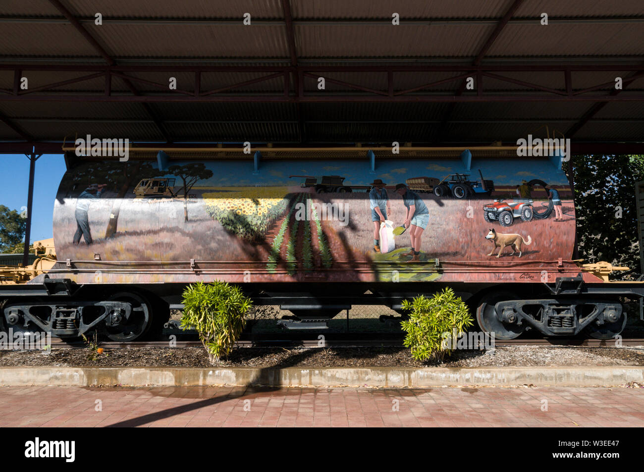 A row of railway wagons on a disused railway line, as a monument with painted local scenes in a small agricultural town at Clermont in Central Queensl Stock Photo