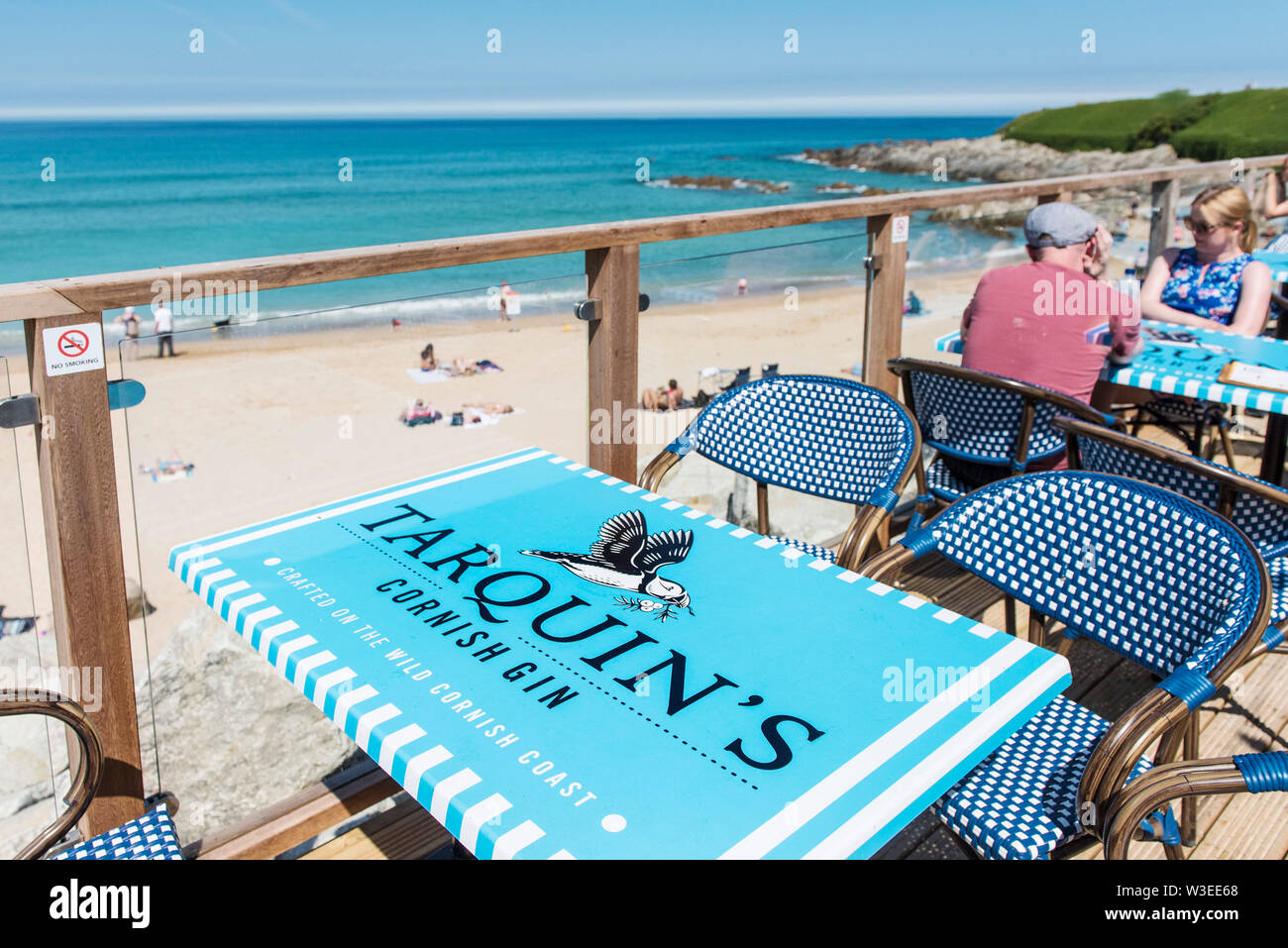 Tables advertising Tarquin’s Gin on the seating deck of the Fistral Beach Bar at Fistral in Newquay in Cornwall. Stock Photo
