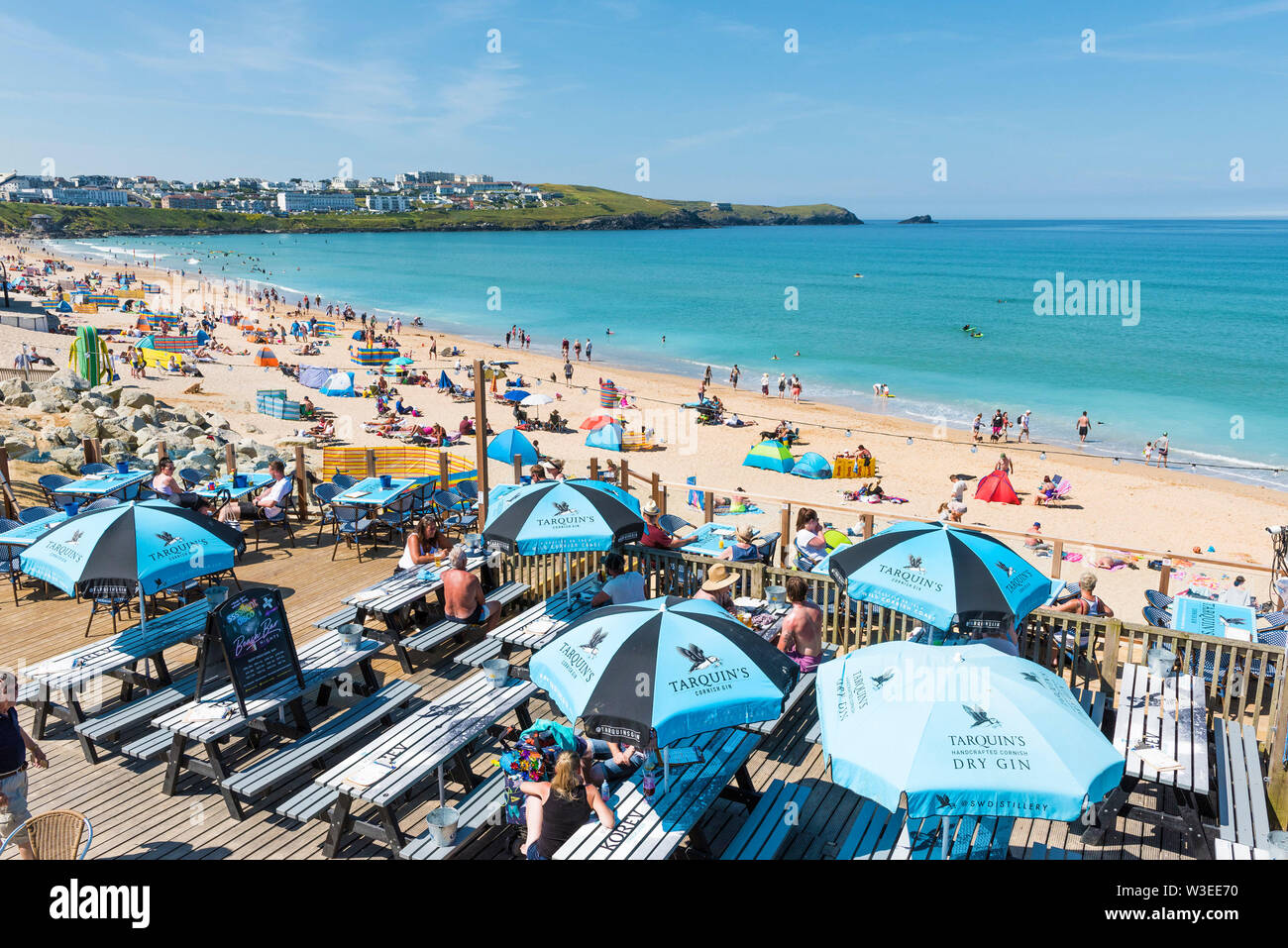 Holidaymakers relaxing and enjoying the sunshine at Fistral Beach and Beach Bar in Newquay in Cornwall. Stock Photo