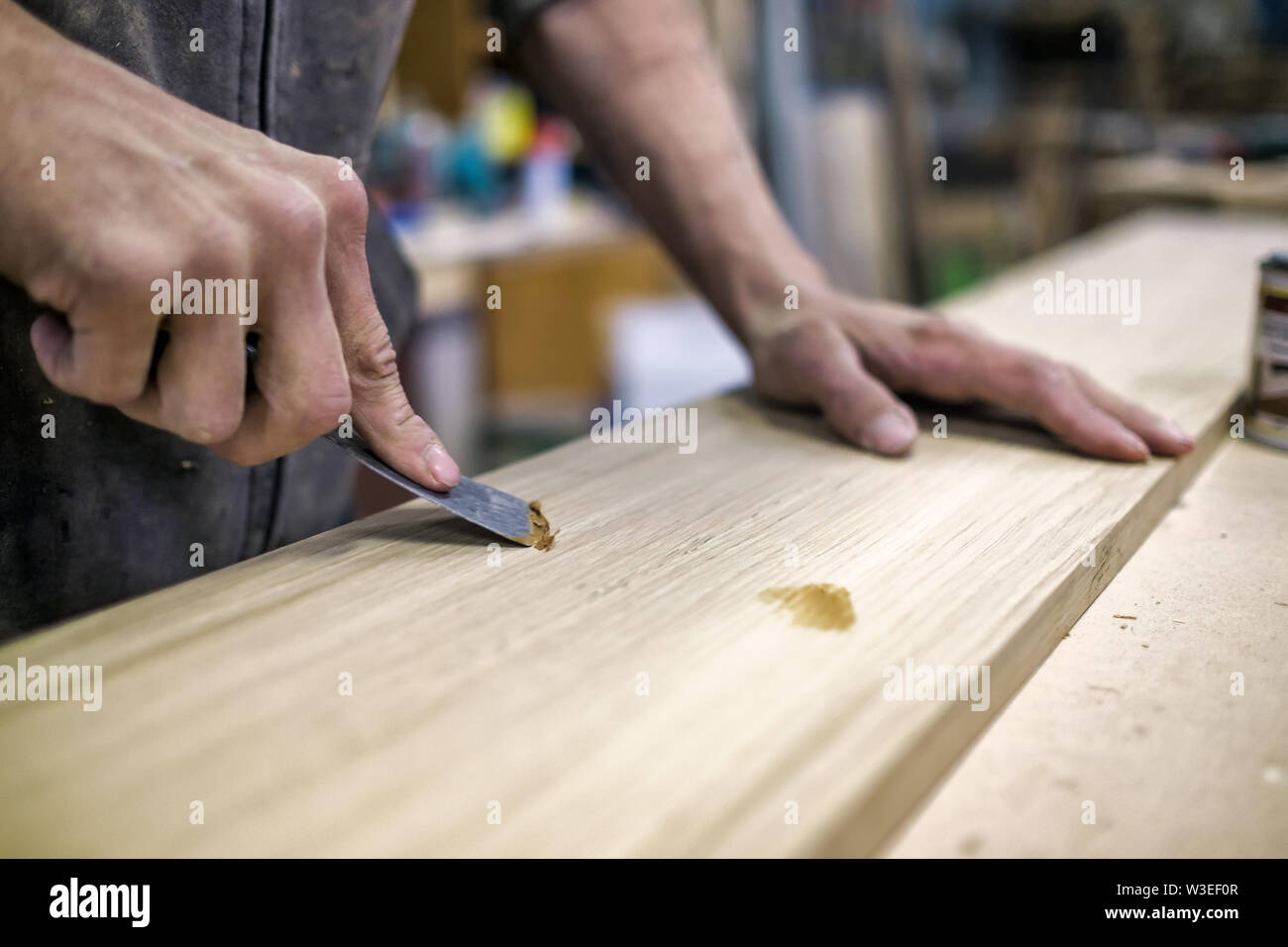 Putty knife in man hand. Removing holes from a wood surface Stock Photo