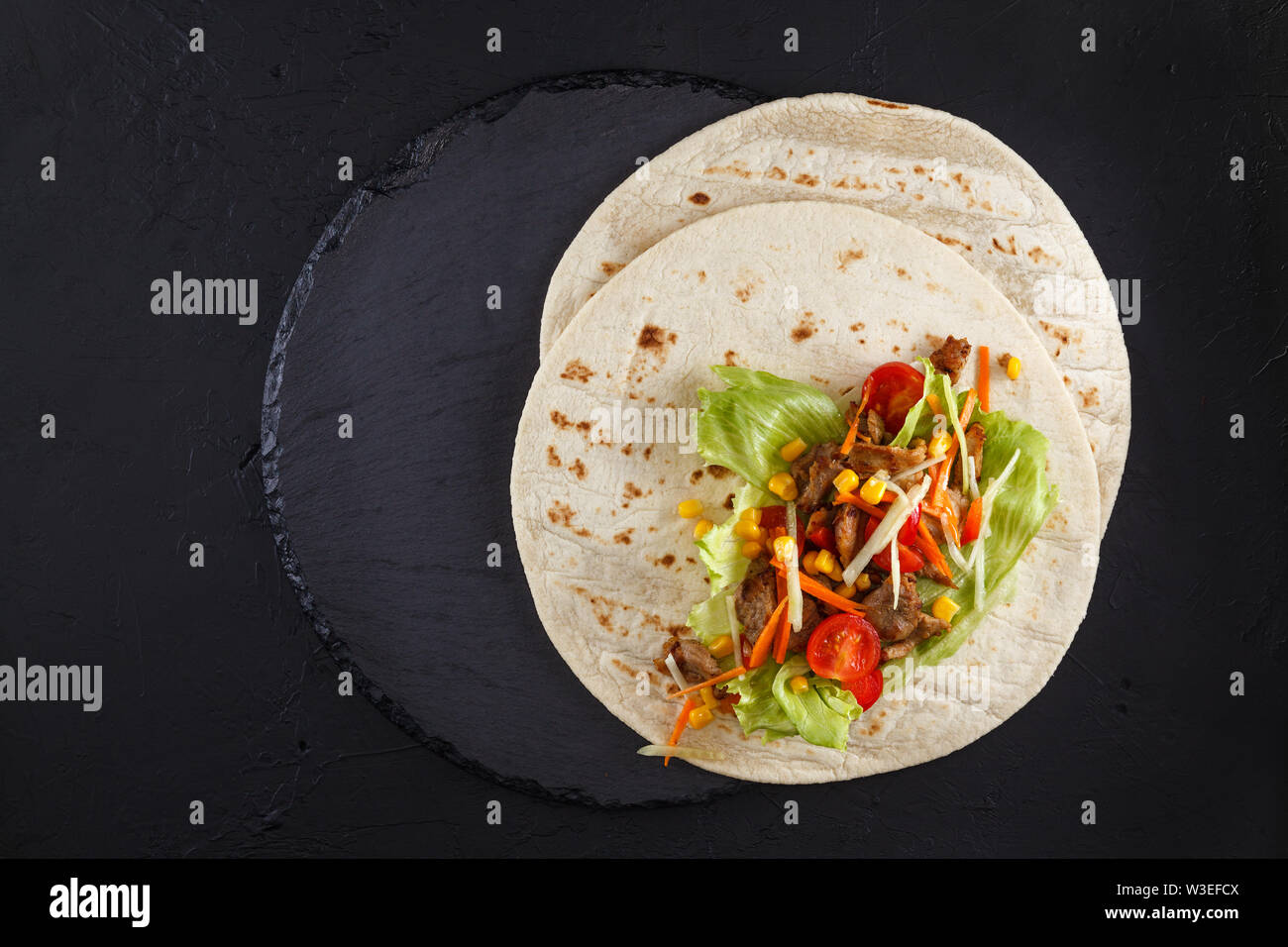 Burritos wraps with chicken and vegetables on black slate. Chicken ...