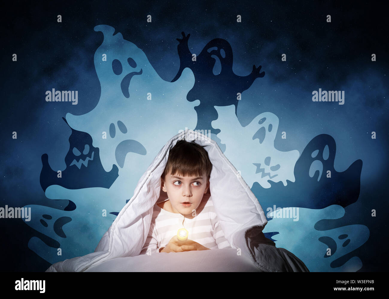 Surprised boy hiding under blanket Stock Photo - Alamy
