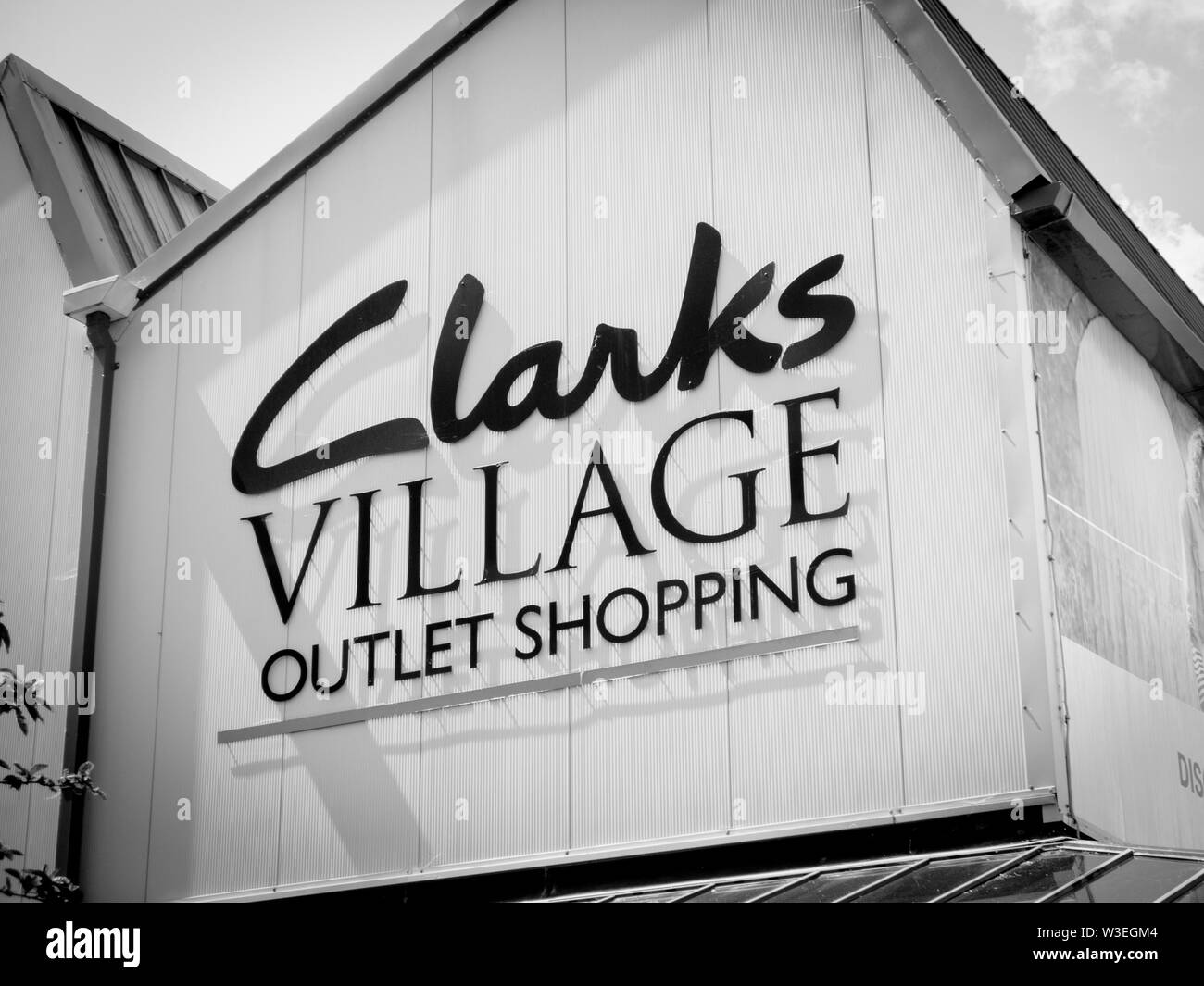 Sign identifying Clarks Village Outlet Centre in Street Somerset England UK Stock Photo