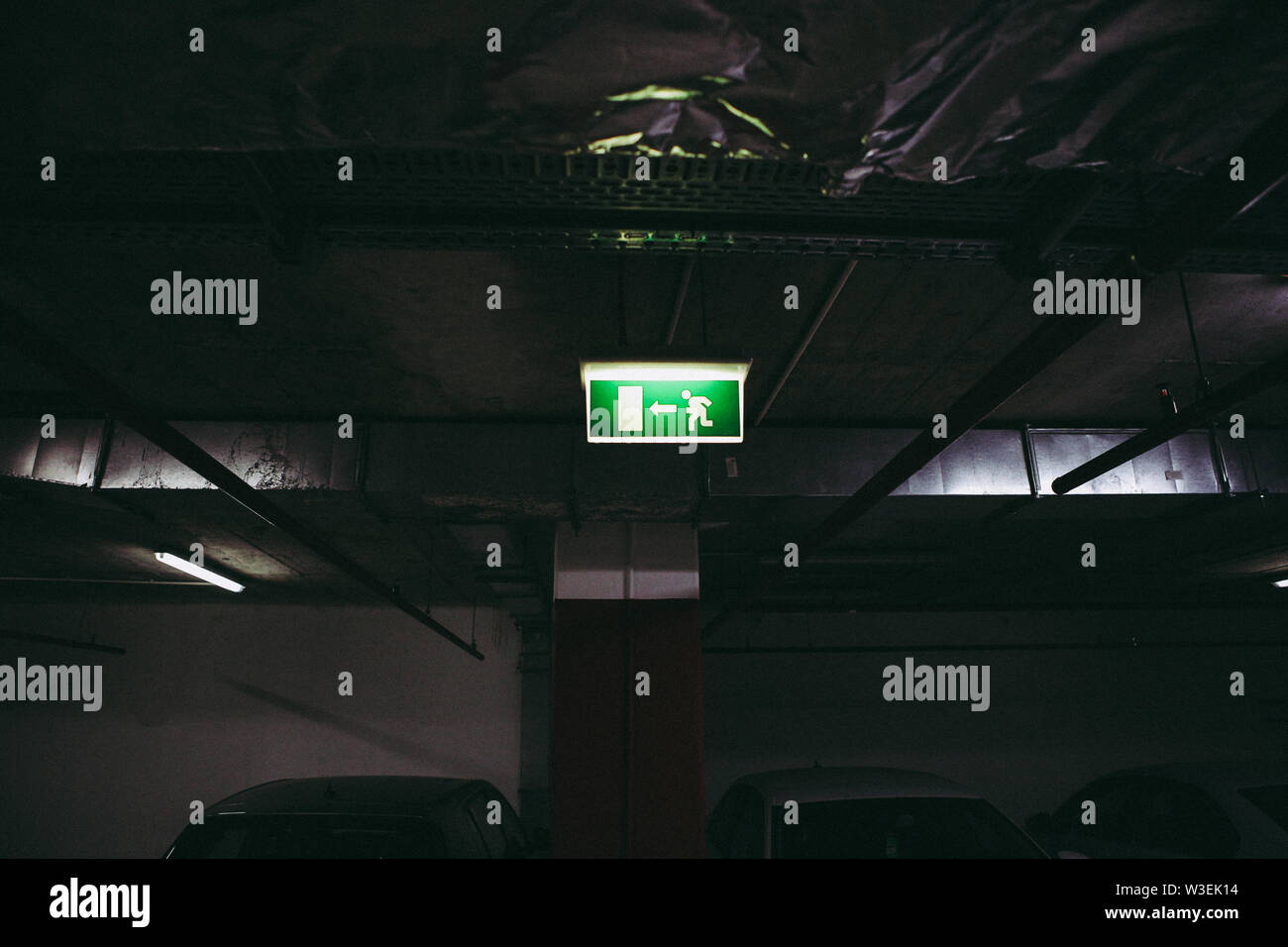 Close up of an exit this way sign inside an underground parking place Stock Photo