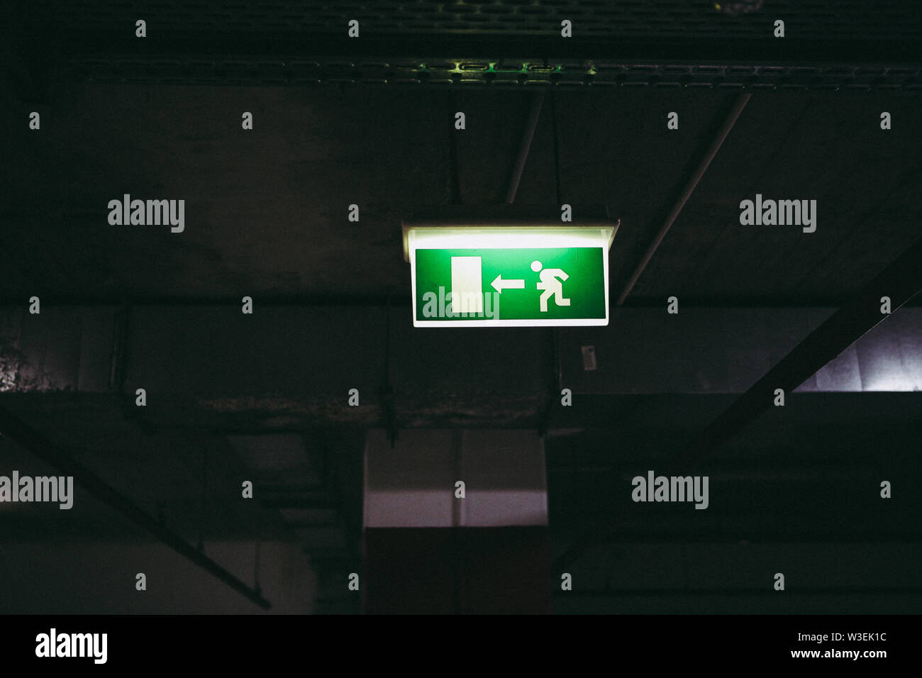 Close up of an exit this way sign inside an underground parking place Stock Photo