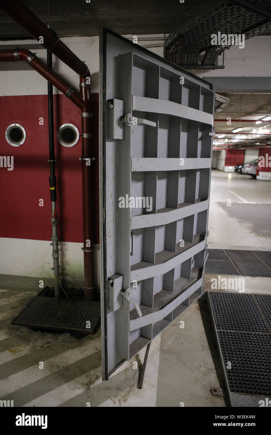 Details with the heavy metal doors of a nuclear explosion shelter (fallout shelter), four stories below ground in a deep underground parking place. Stock Photo