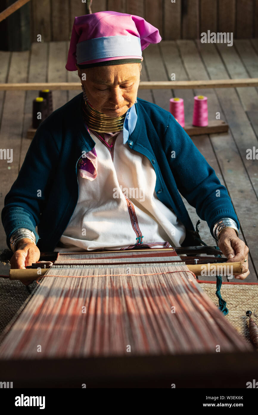 Inle, Myanmar - March 2019: Kayan Lahwi tribe long neck woman sits behind the loom in a tourist shop on Inle lake Stock Photo