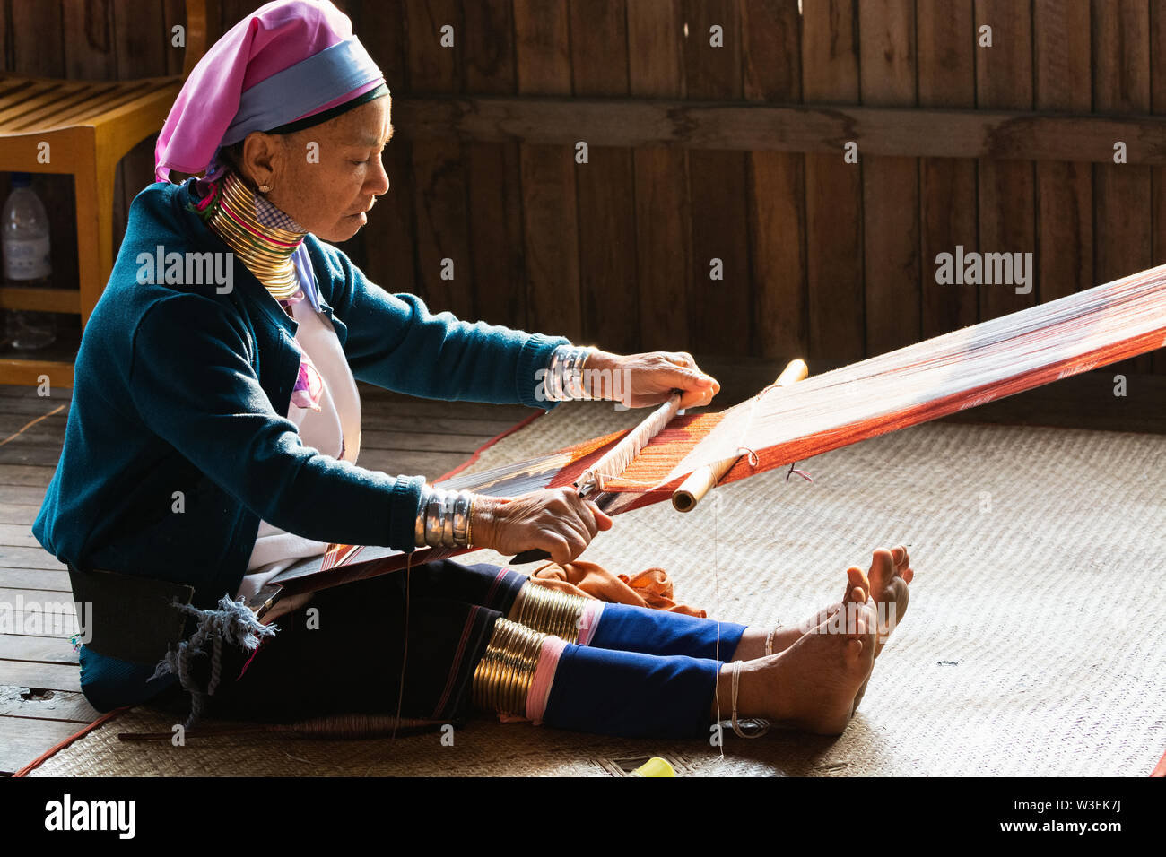 Inle, Myanmar - March 2019: Kayan Lahwi tribe long neck woman sits behind the loom in a tourist shop on Inle lake Stock Photo