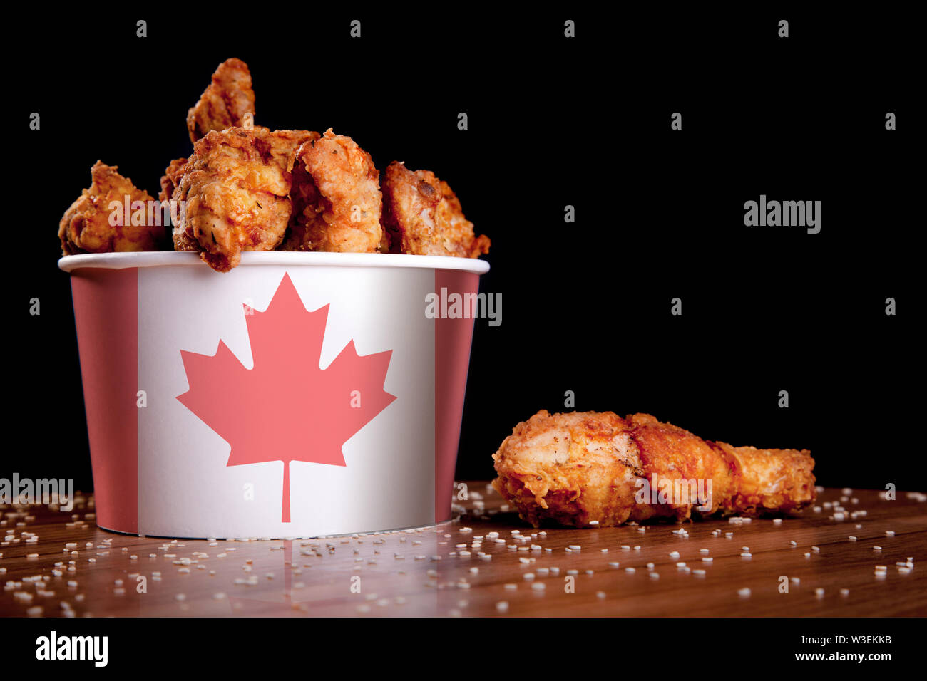 bbq-chicken-wings-in-bucket-flag-of-canada-on-a-wooden-table-and-black-background-W3EKKB.jpg