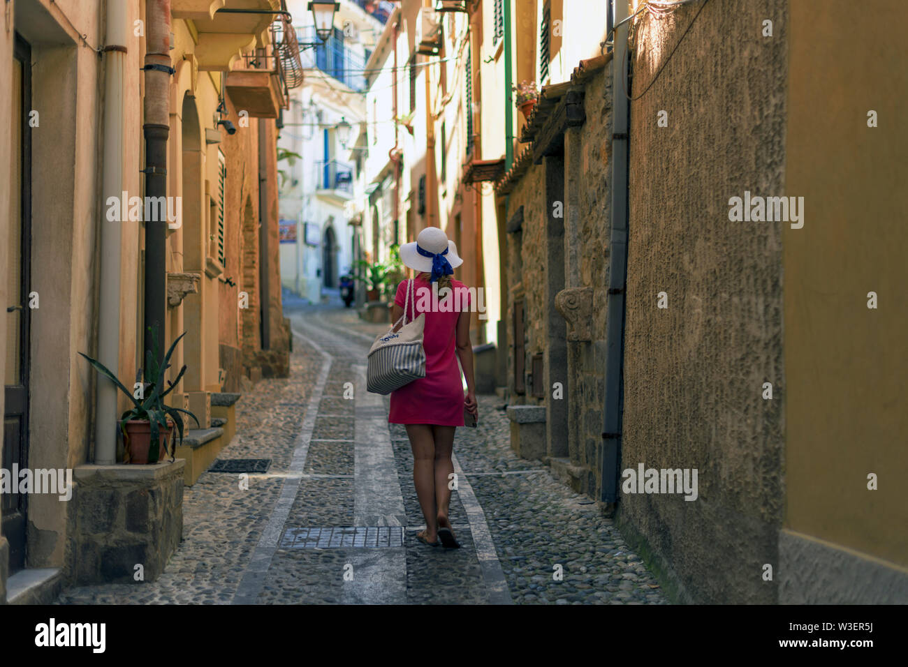 Young caucasian woman exploring an old charming italian city located in calabria. Stock Photo