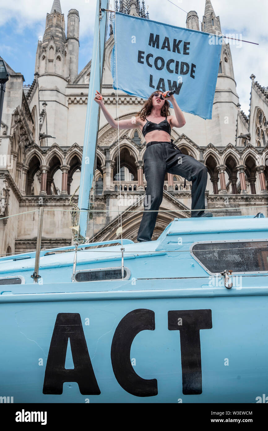 London, UK. 15th July 2019. Jessica Winter performs on the boat after performing at Oxford Circus at the last protest - Extinction Rebellion block Fleet Street outside the Royal Courts of Justice as part of a new round of environmental protests, with their new blue boat the Polly Higgins - named after a woman who died of cancer on the April protest while promoting her idea for an Ecocide Law. Credit: Guy Bell/Alamy Live News Stock Photo