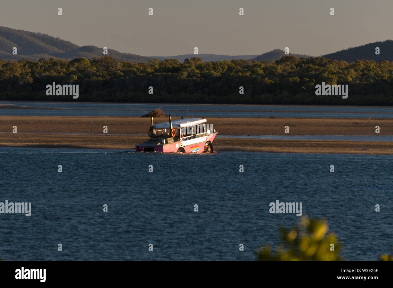 A huge tourist carrying land/sea vehicle emerging from the water onto a sand bank at Bustard Bay near the small coastal town of 1770 in Queensland, Au Stock Photo