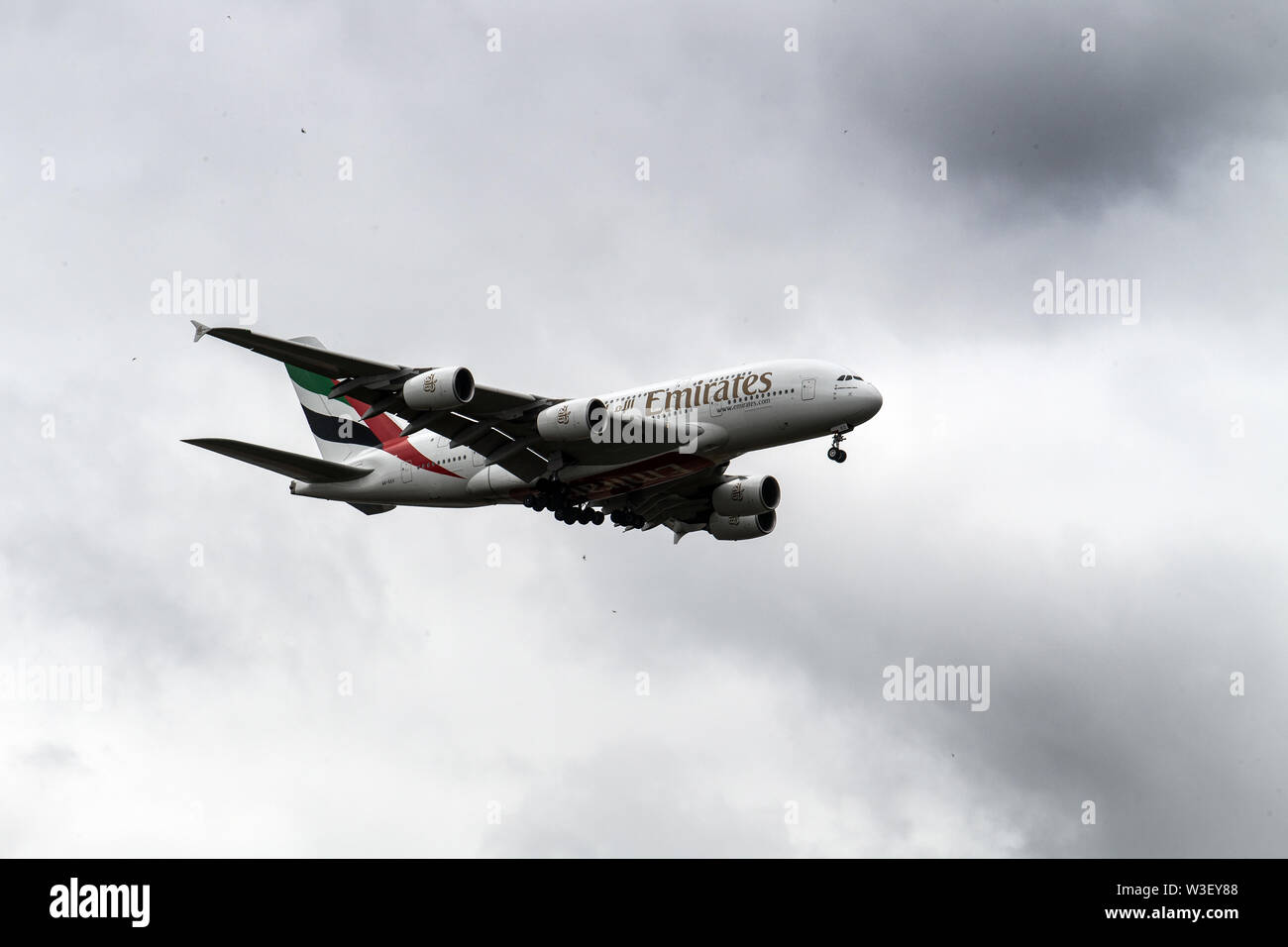 Duesseldorf, Germany. 15th July, 2019. Under a closed cloud cover, an Airbus A380 of the airline Emirates is making its final approach to Düsseldorf Airport. Credit: Federico Gambarini/dpa/Alamy Live News Stock Photo