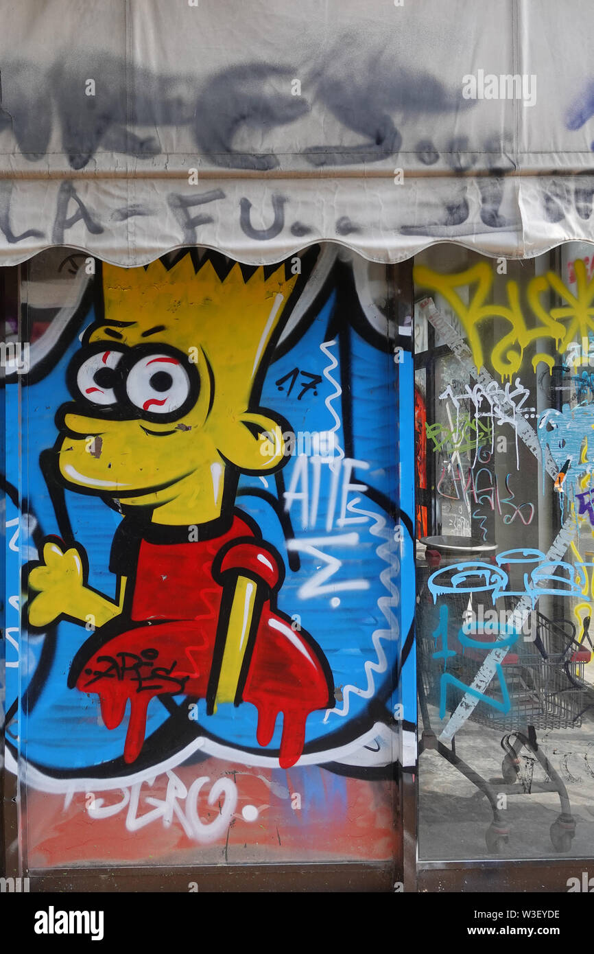 ATHENS, GREECE - MARCH 31, 2019: Bart Simpson graffiti and tagging on glass storefront of an abandoned shop. Stock Photo