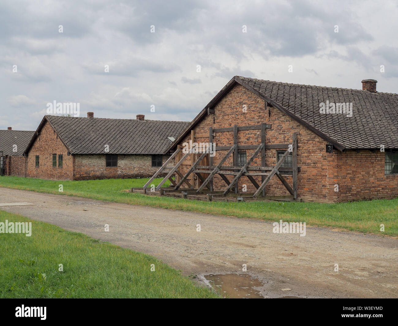 Auschwitz Birkenau Nazi Concentration Camp in Poland under dark cloud Stock Photo