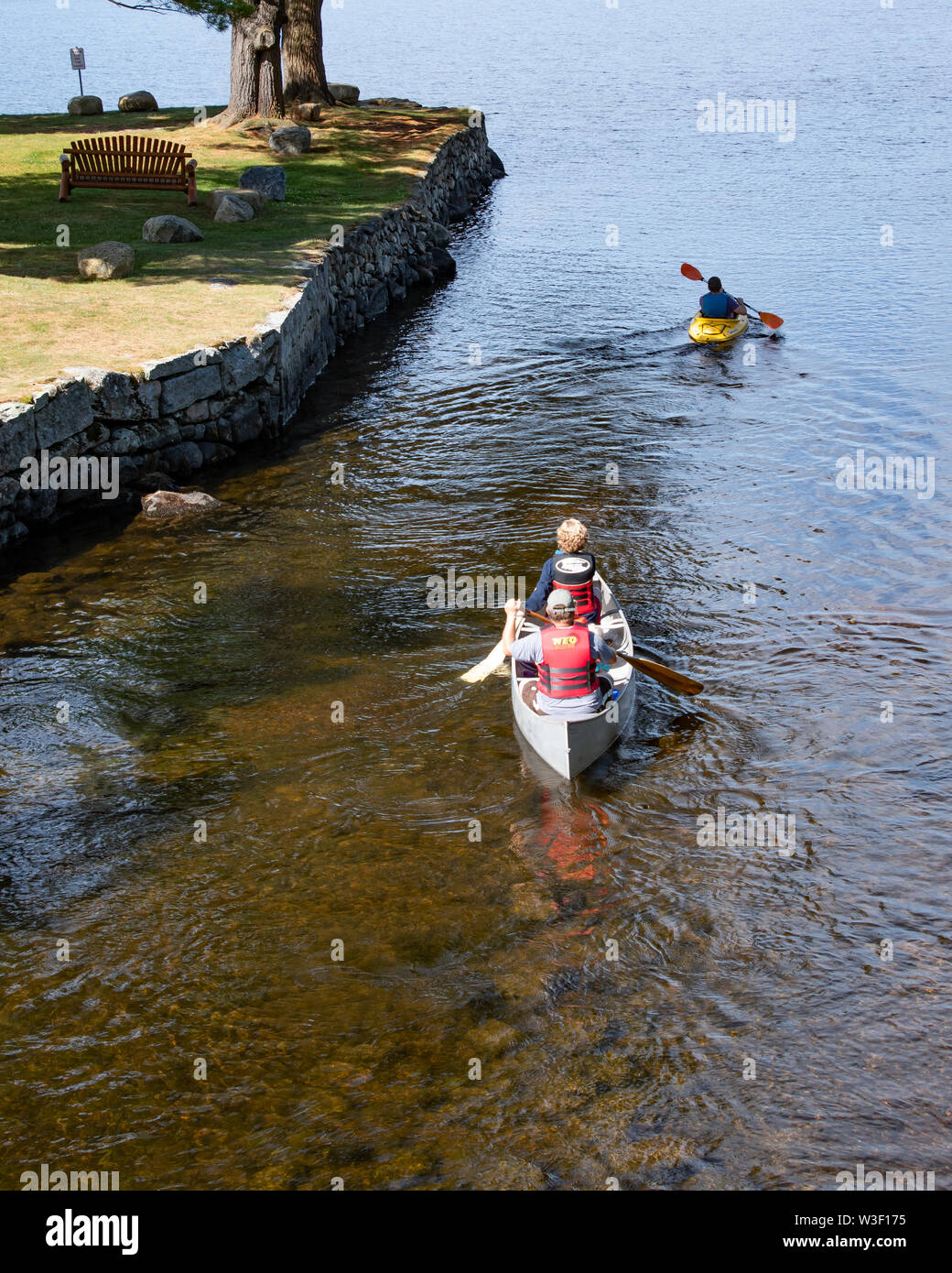 People paddling an aluminum canoe and a plastic kayak into Lake Pleasant from the launch on the Sacandaga River in Speculator, NY USA Stock Photo
