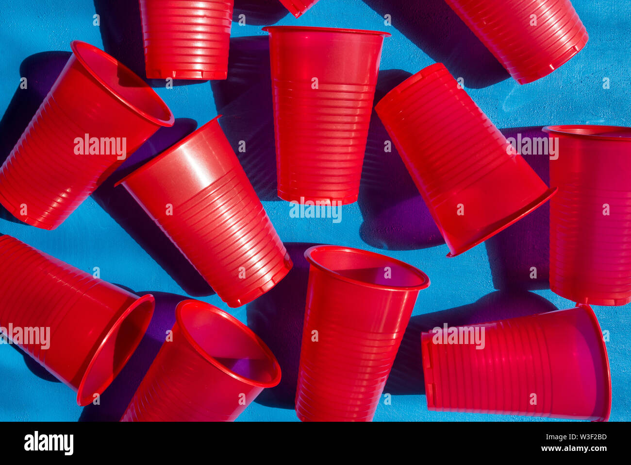 https://c8.alamy.com/comp/W3F2BD/red-plastic-cups-on-a-blue-background-composition-from-empty-plastic-glasses-many-disposable-beverage-containers-view-from-above-W3F2BD.jpg