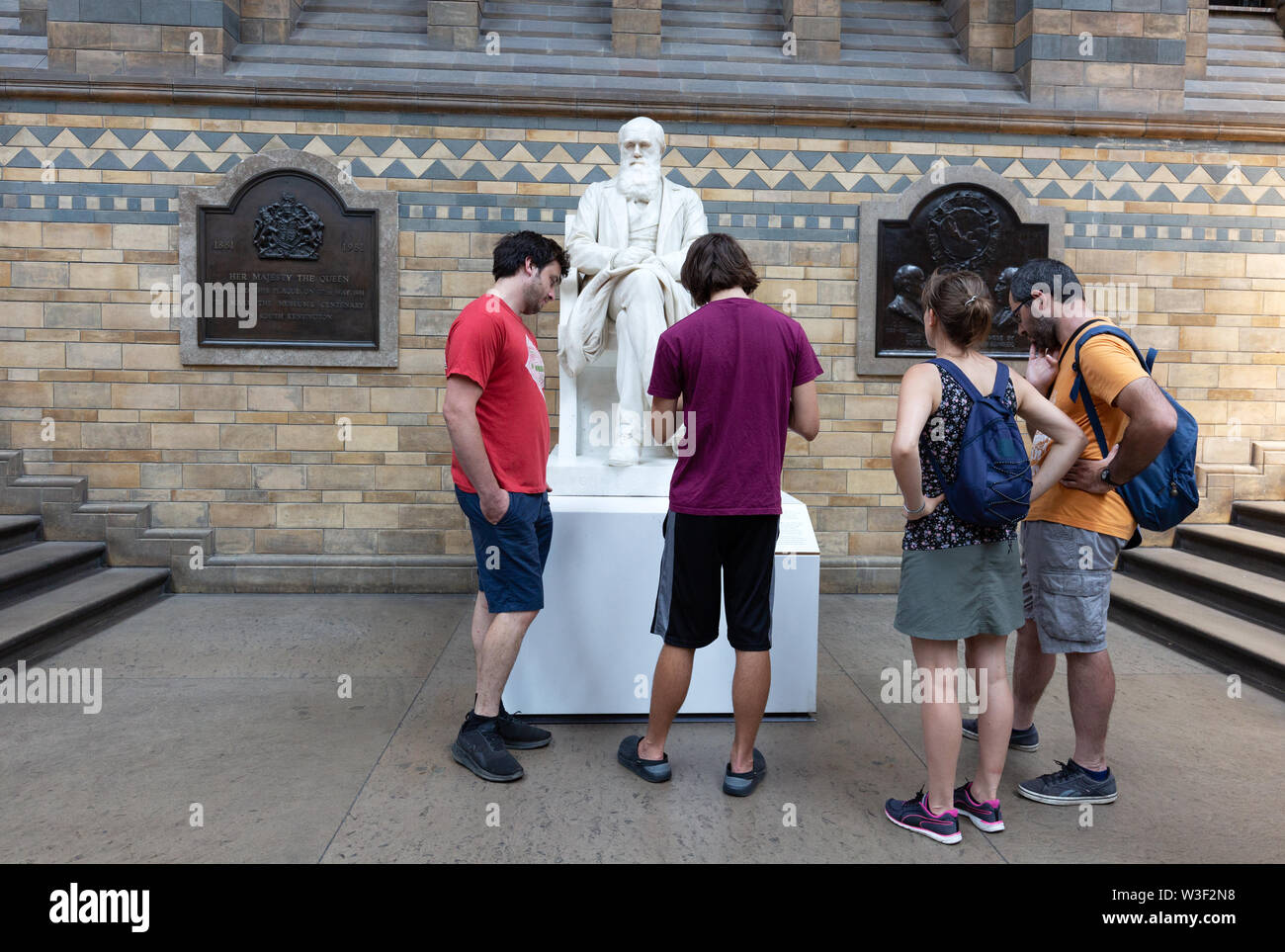 People looking at the statue of Charles Darwin, the Natural History Museum, London UK Stock Photo