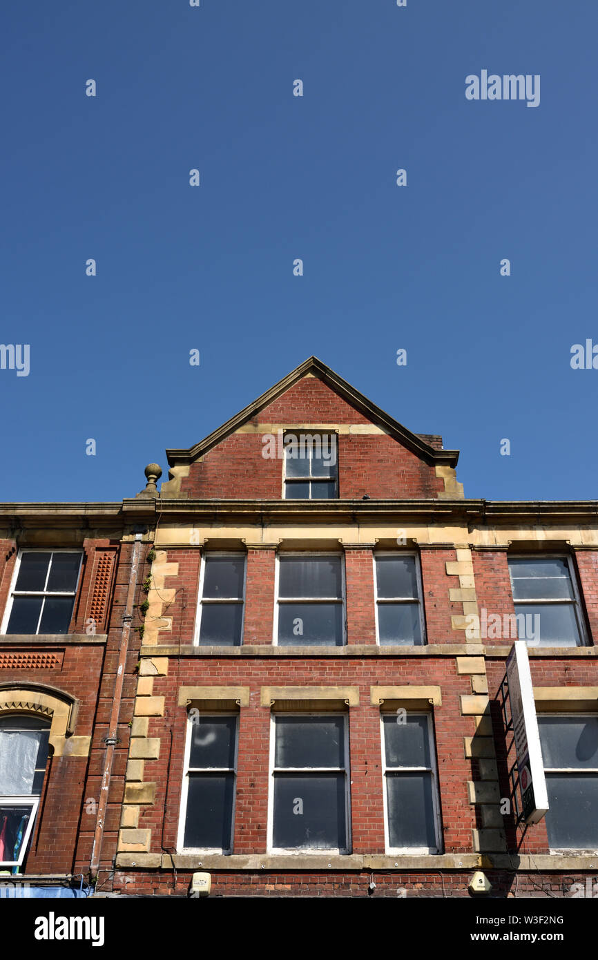 Red brick building facade showing three storeys and windows low angle view in bury lancashire uk Stock Photo