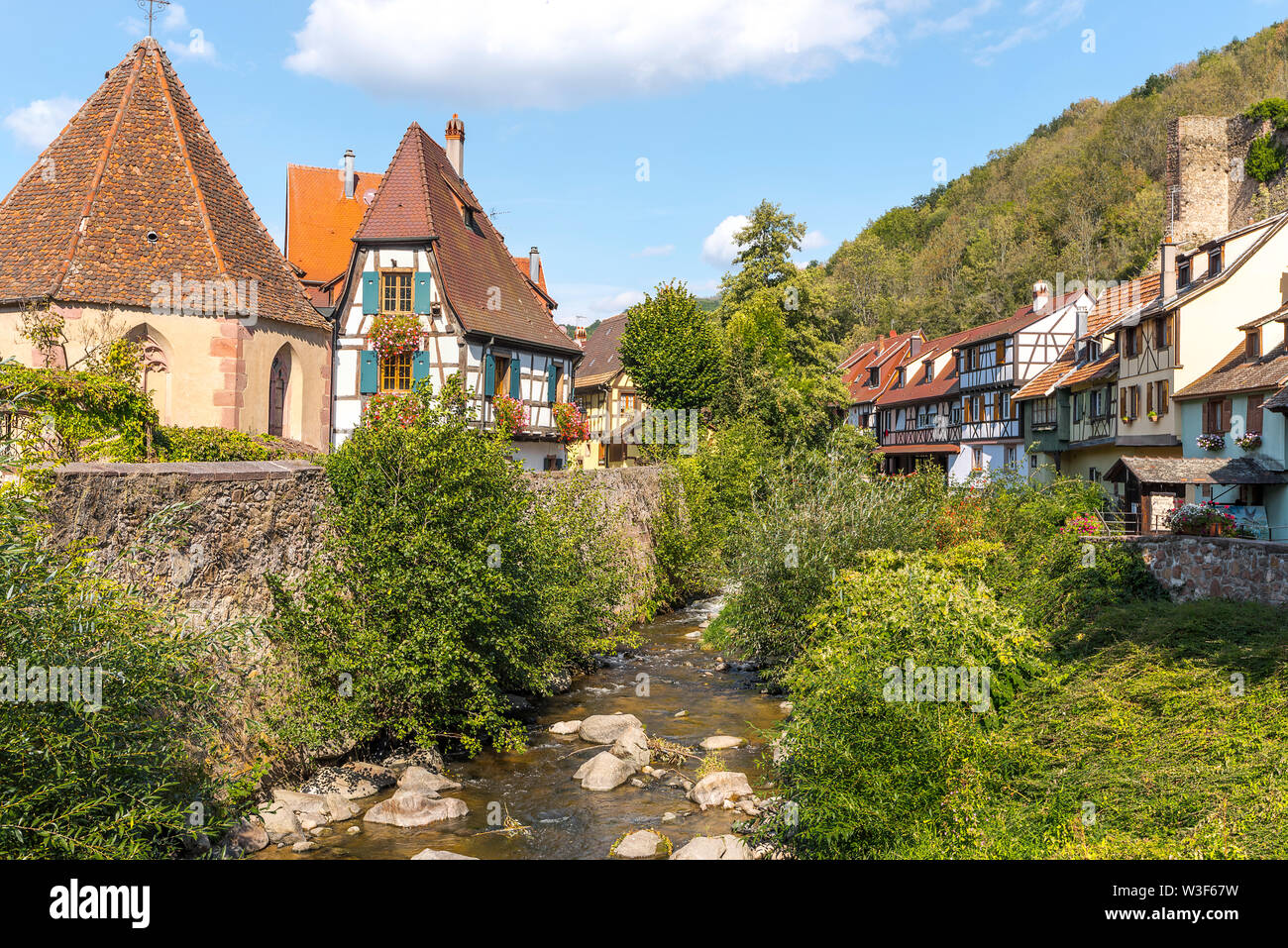 scenic corner in the centre of the village Kaysersberg, Alsace Wine Route, France, old half-timbered houses and Chapelle de l'Oberhof at the river Stock Photo