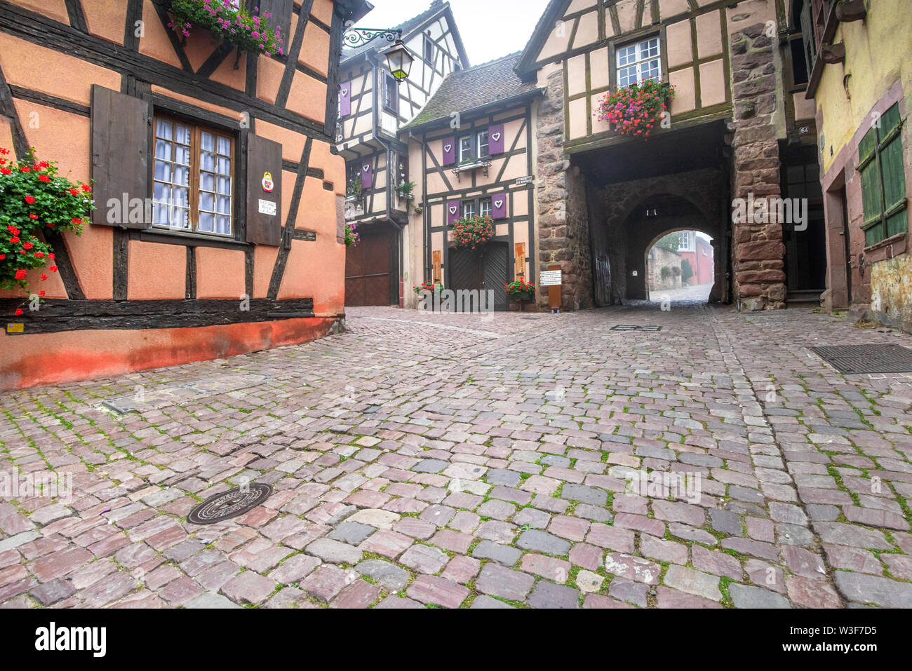 lane in the village Riquewihr, Alsace, France, town gate and half-timbered houses Stock Photo