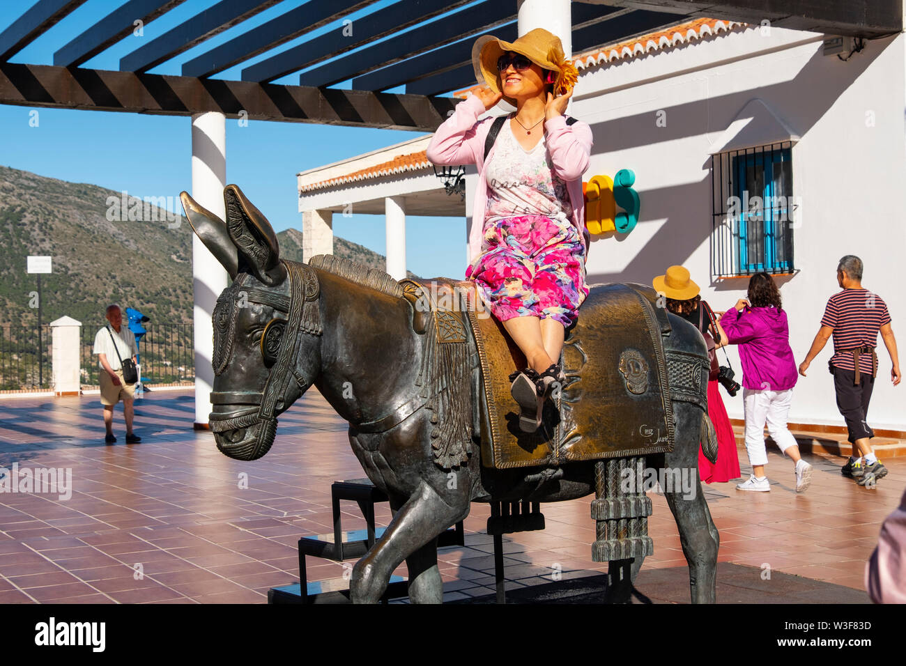 Oriental tourists riding the typical donkey taxi, white village of Mijas. Malaga province Costa del Sol. Andalusia, Southern Spain Europe Stock Photo