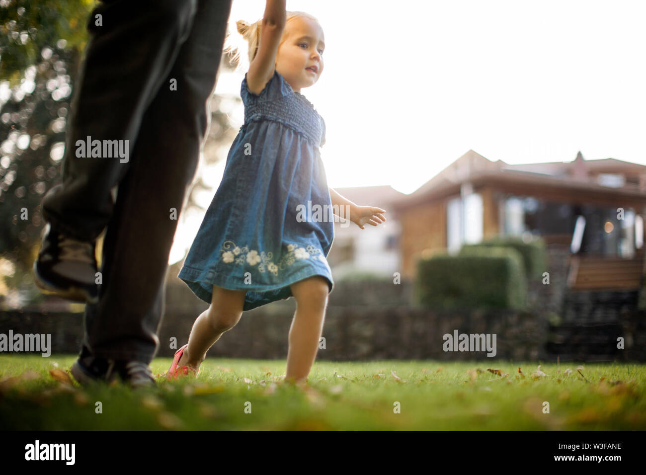 Happy young girl walking hand in hand with her father Stock Photo - Alamy
