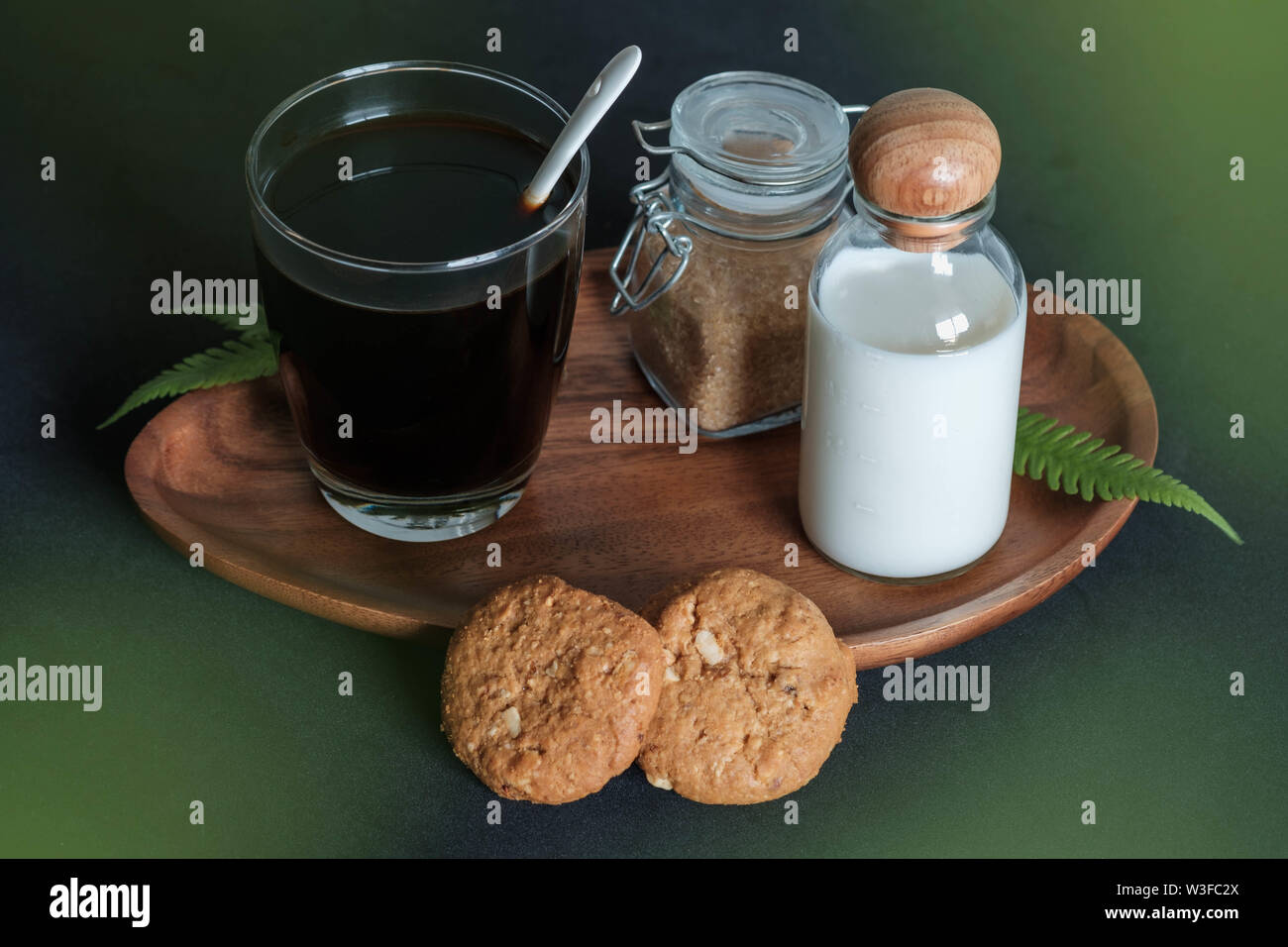 Glass of coffee with brown sugar and milk cookies and cinnamon Stock Photo