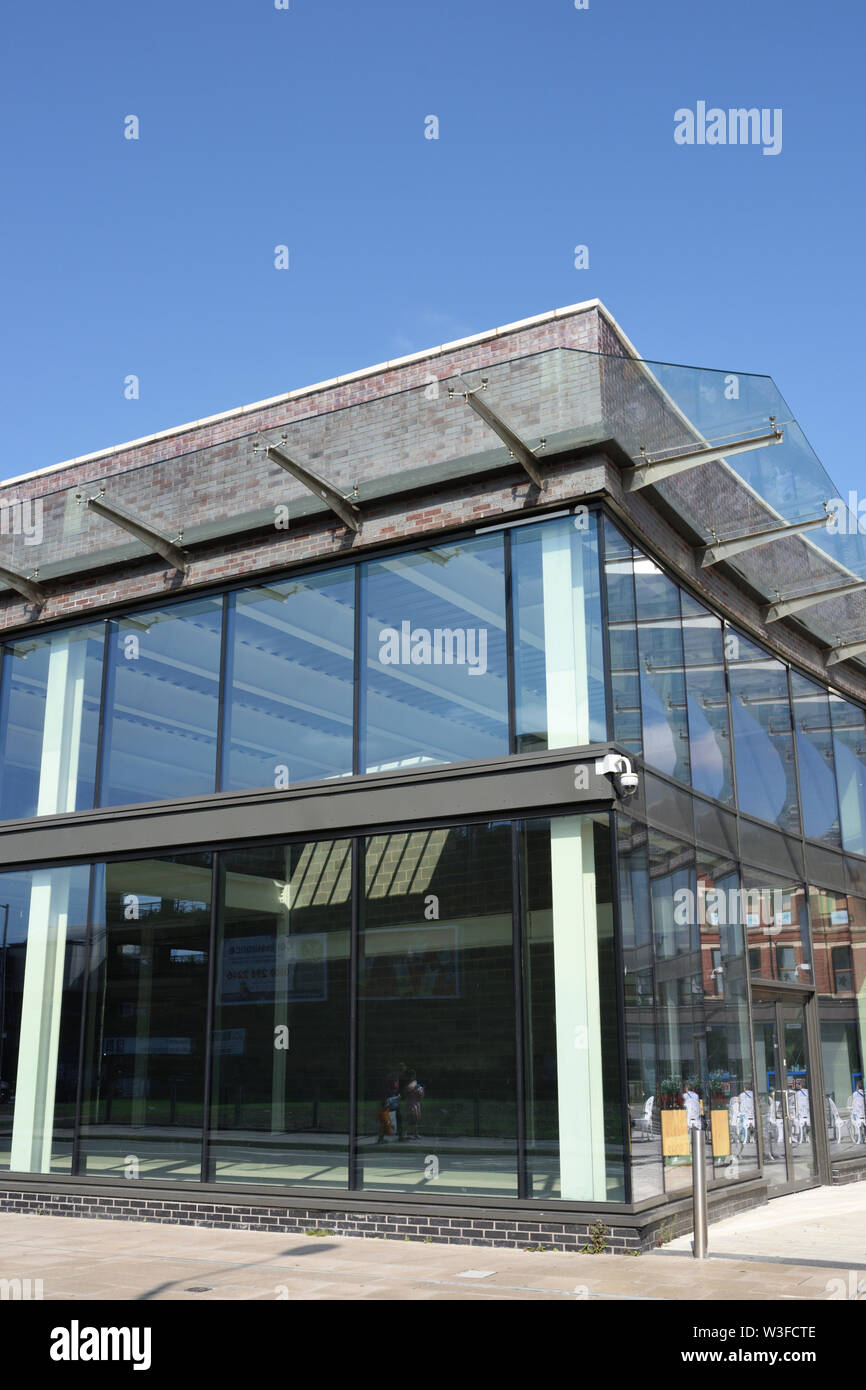Glass curtain walling and cantilevered glass canopy on modern commercial building exterior in