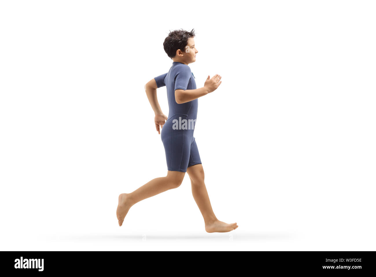 Full length profile shot of a boy in a wetsuit running isolated on white background Stock Photo