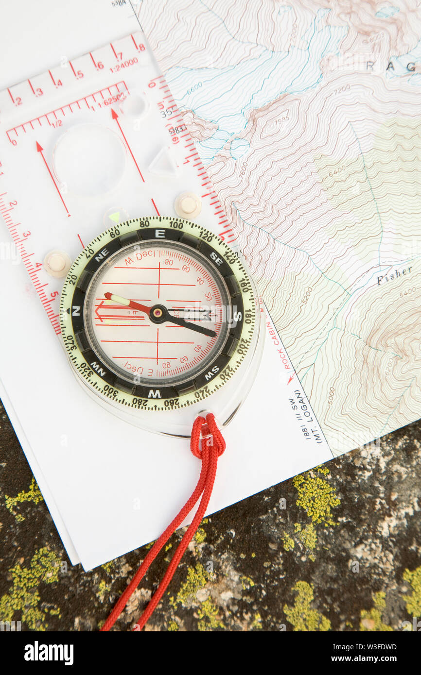 Topographic map and compass on lichen-covered rock. Navigation ...