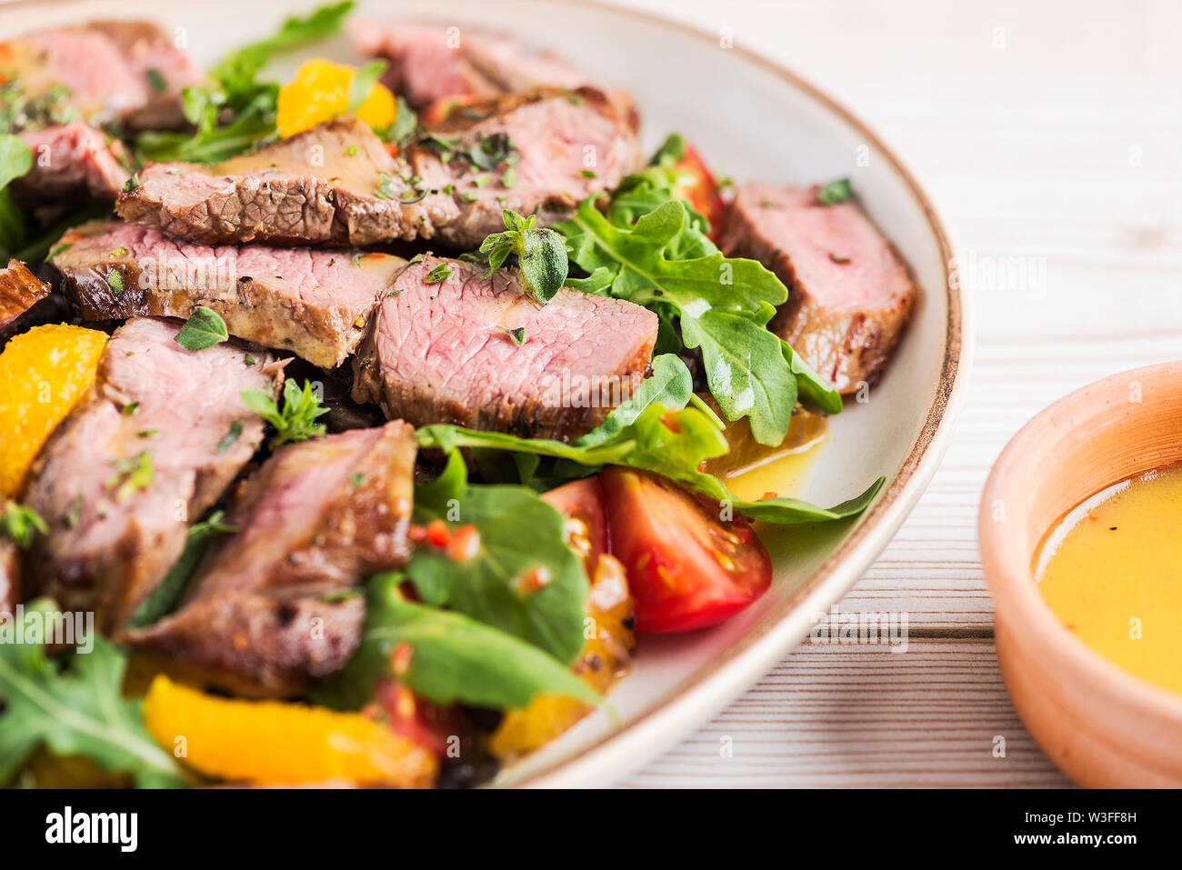 Sliced lamb leg steak salad with black beans, orange and chilli. Close up detailing salad and sauce Stock Photo