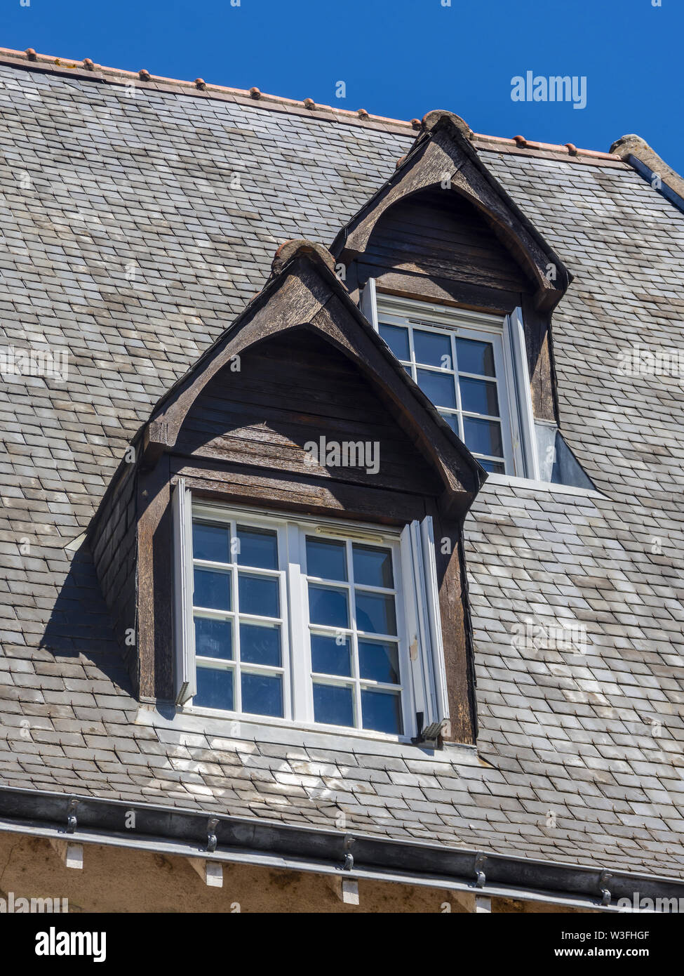 Dormer windows on steeply pitched slate roof - Tours, France. Stock Photo