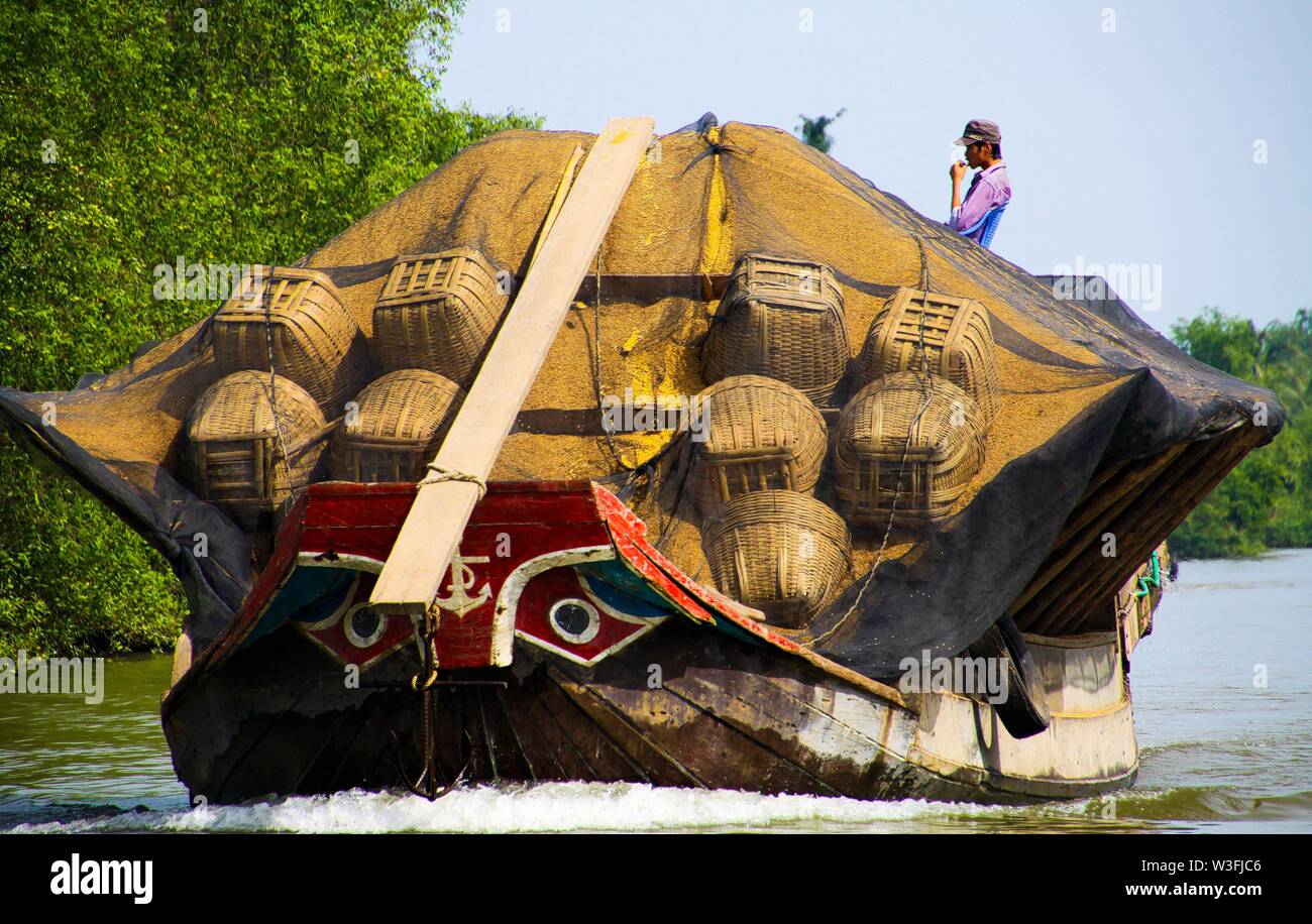 MEKONG DELTA, VIETNAM: DECEMBER 30. 2014: Overloaded sampan style boat with  typical stylized bow eyes Stock Photo - Alamy, image size:1300x916