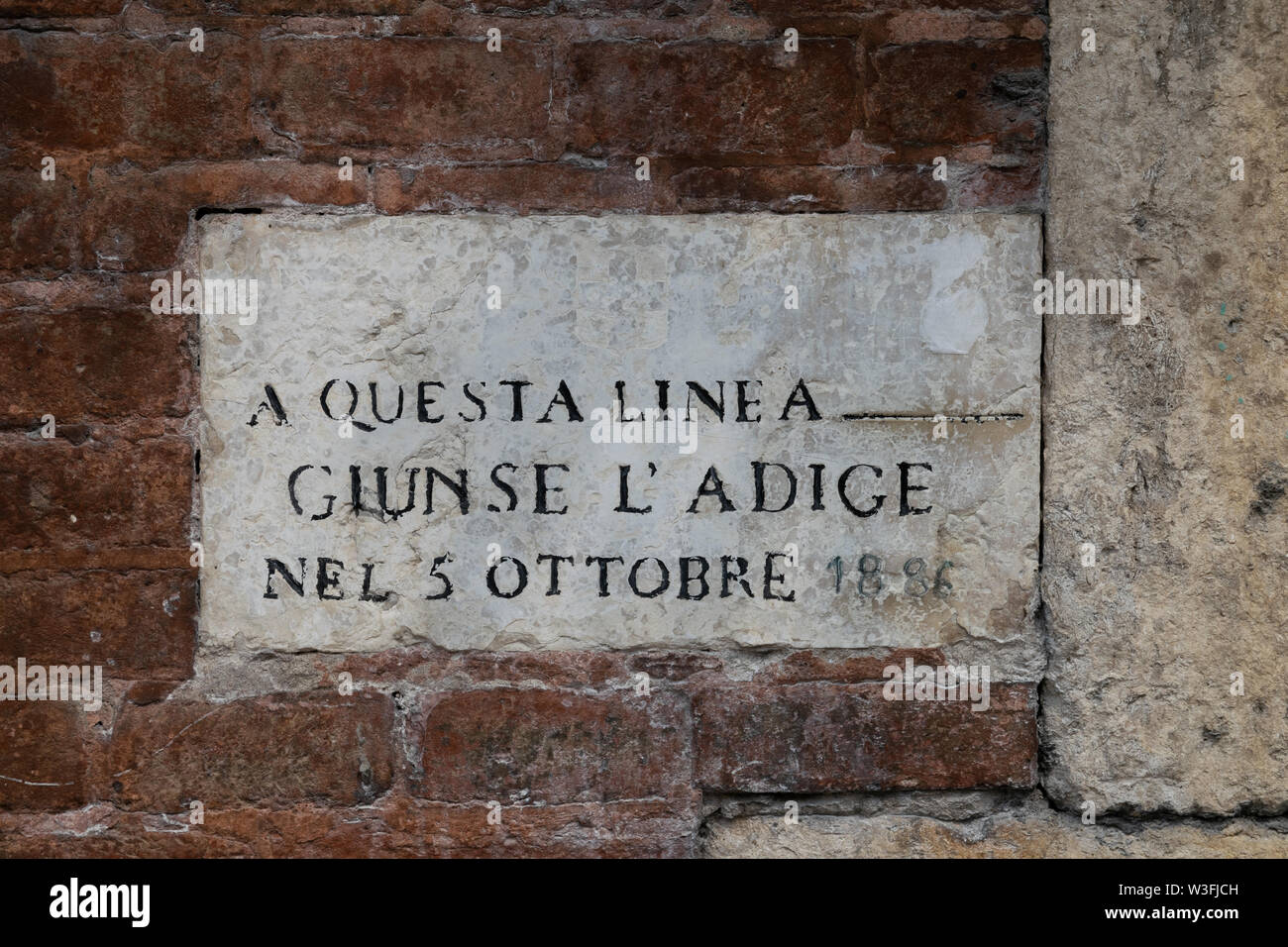 Stone on a wall marking the level of the river Adige in Verona in October 1886 Stock Photo
