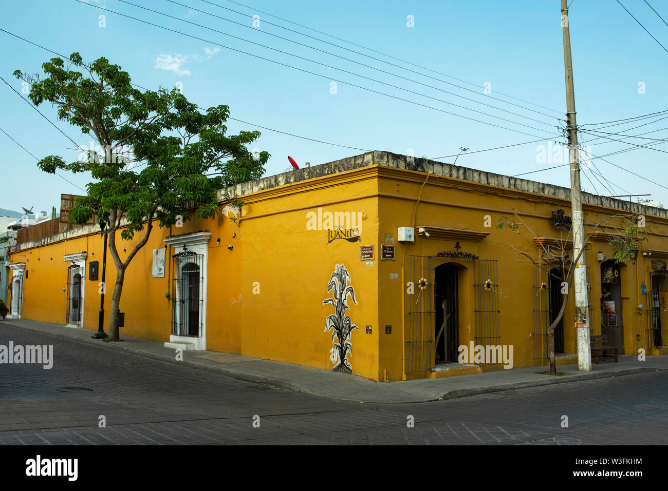 Bright painted, single-storey colonial building with traditional Mexican restaurant on Manuel Bravo street, downtown Oaxaca, Mexico. Apr 2019 Stock Photo