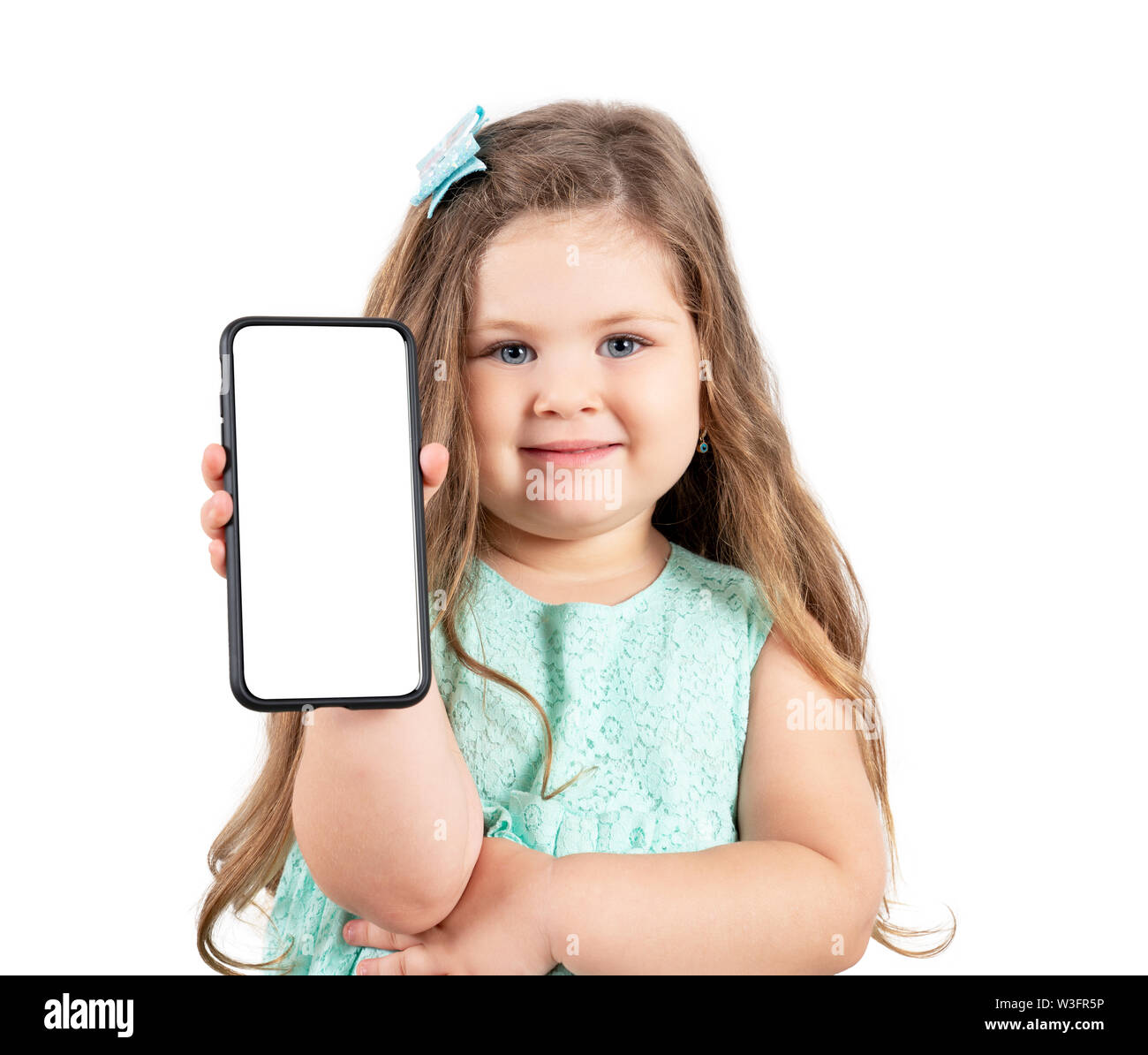 little girl holding a smartphone with a white screen. Stock Photo