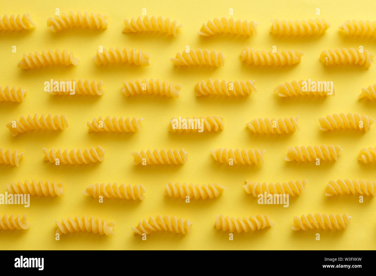 Download Raw Fusilli Pasta Over Yellow Background Jpg Stock Photo 260349709 Alamy PSD Mockup Templates