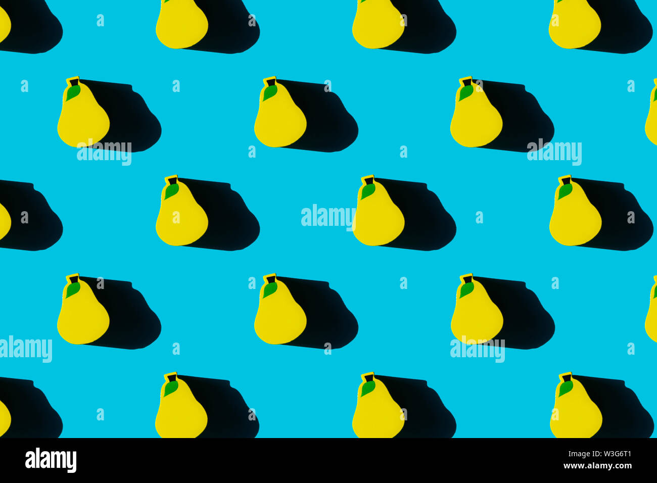 Colorful fruit pattern of yellow wooden pears on blue background. Top view. Stock Photo