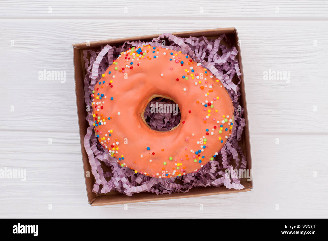 Donut in box on white wooden background Stock Photo - Alamy