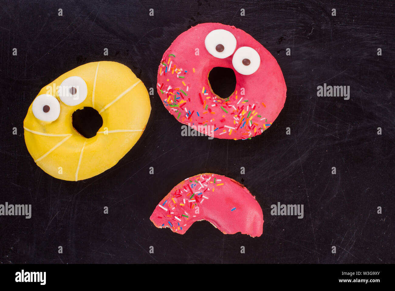 Two colorful donuts on dark background. Stock Photo