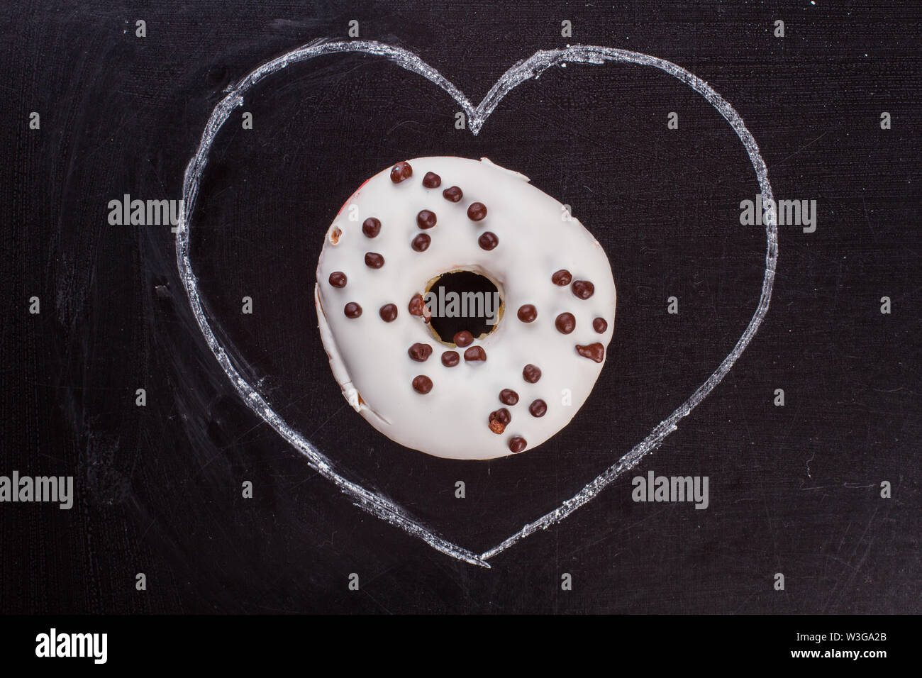 Drawn heart and donut on black background Stock Photo - Alamy