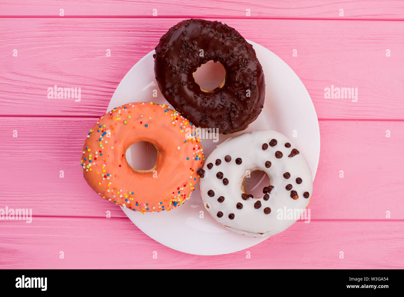Three donuts on plate, top view. Stock Photo
