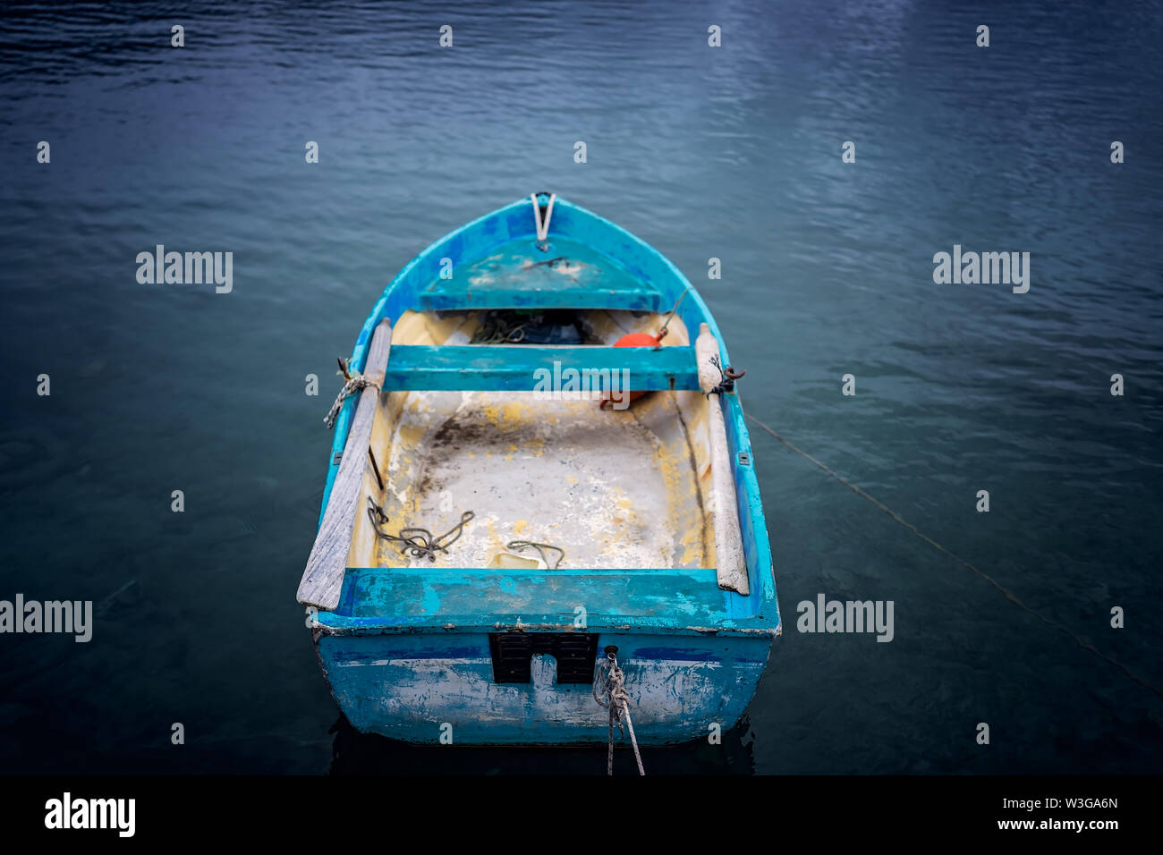 Small blue wooden rowing fisherman boat in the port and harbour in the Alykes Bay in Zante, Greece Stock Photo