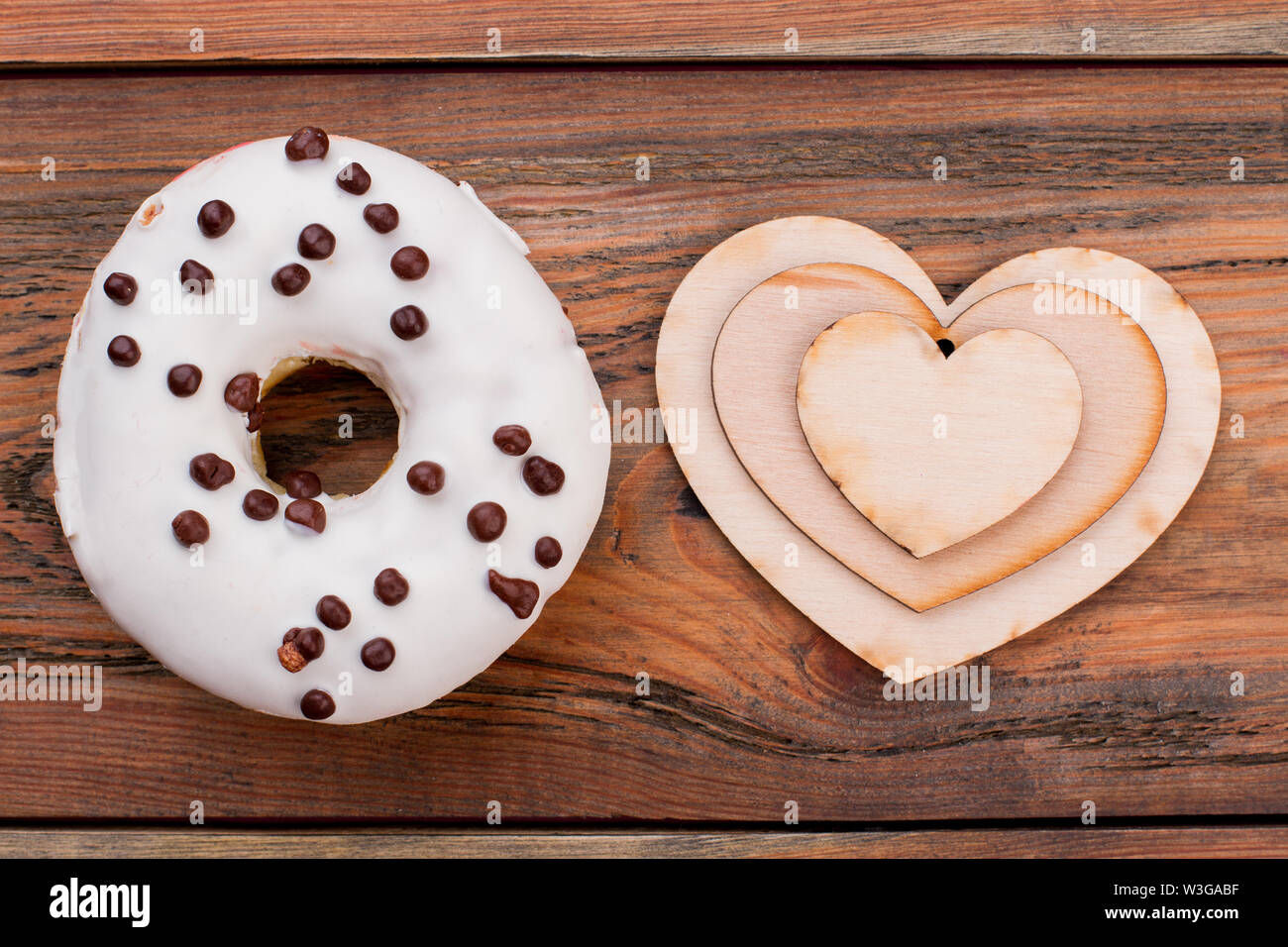 White glazed donut and wooden hearts Stock Photo - Alamy