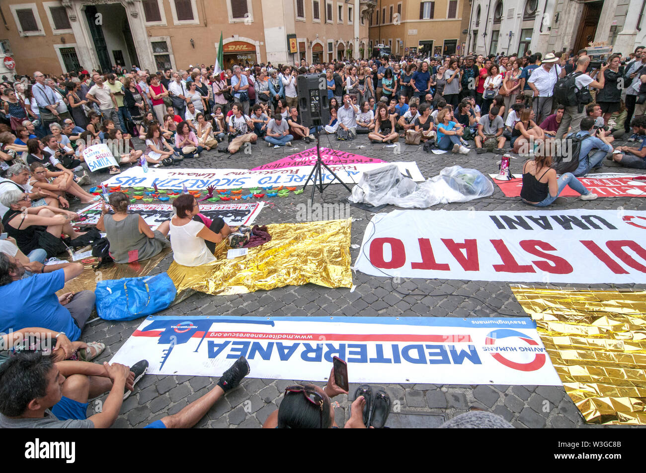 Rome, Italy. 15th July, 2019. Sit-in in front of the Chamber of Deputies (Montecitorio) against the Security Bis Decree organized by the Network Restiamo Umani. This morning a disproportionate number of police forces evacuated a former occupied school in the Primavalle district where about 300 people lived, including many children and former occupants, and the realities that had opposed the eviction this morning returned to Montecitorio in the afternoon. The parliamentarians Nicola Fratoianni and Riccardo Magi are also in the streets. Credit: Patrizia Cortellessa/Pacific Press/Alamy Live News Stock Photo