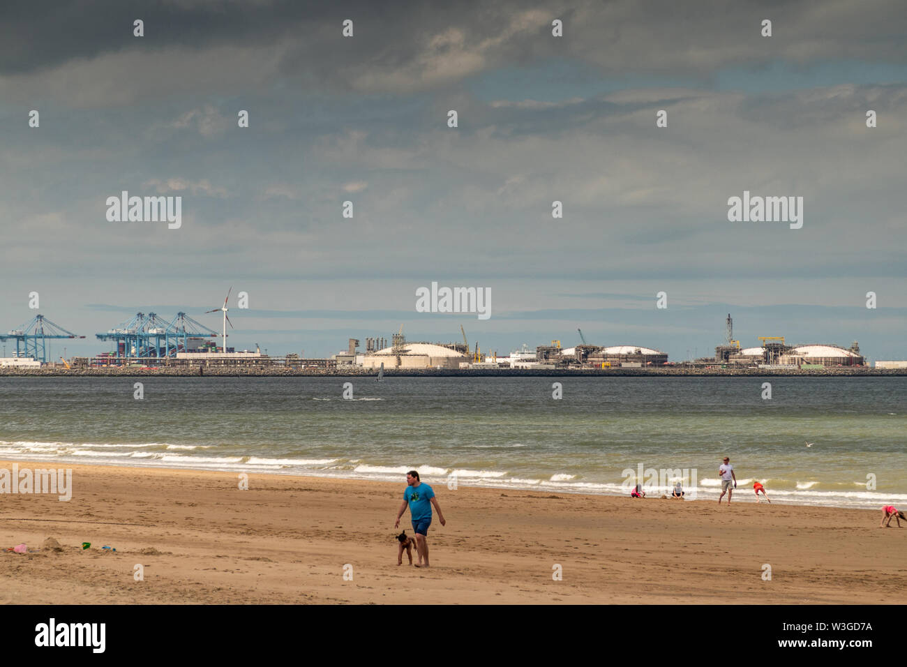 Knokke-Heist, Flanders, Belgium -  June 16, 2019: Knokke-Zoute part of town. View from sandy beach on LNG sea terminal and container cranes of Port of Stock Photo