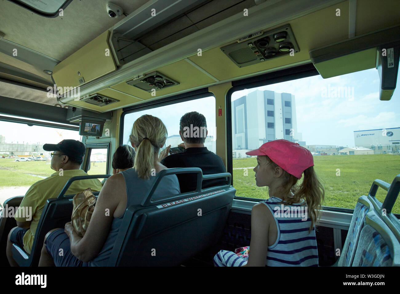 tourists on bus tour of the Kennedy Space Center pass the VAB Vehicle Assembly Building Florida USA Stock Photo