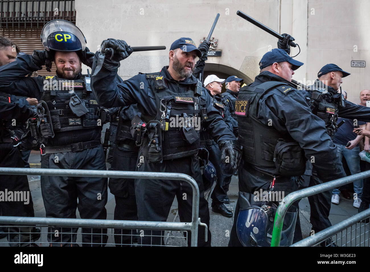 London, UK. 11th July 2019. Angry scenes of civil unrest outside Old Bailey court between riot police and supporters of Tommy Robinson. Sentenced under his real name of Stephen Yaxley-Lennon, a custodial sentence of 19 weeks is ordered after Tommy Robinson was found guilty of contempt of court over the filming outside Leeds Crown Court during a criminal trial last year and broadcasting live on social media. Credit: Guy Corbishley/Alamy Live News Stock Photo