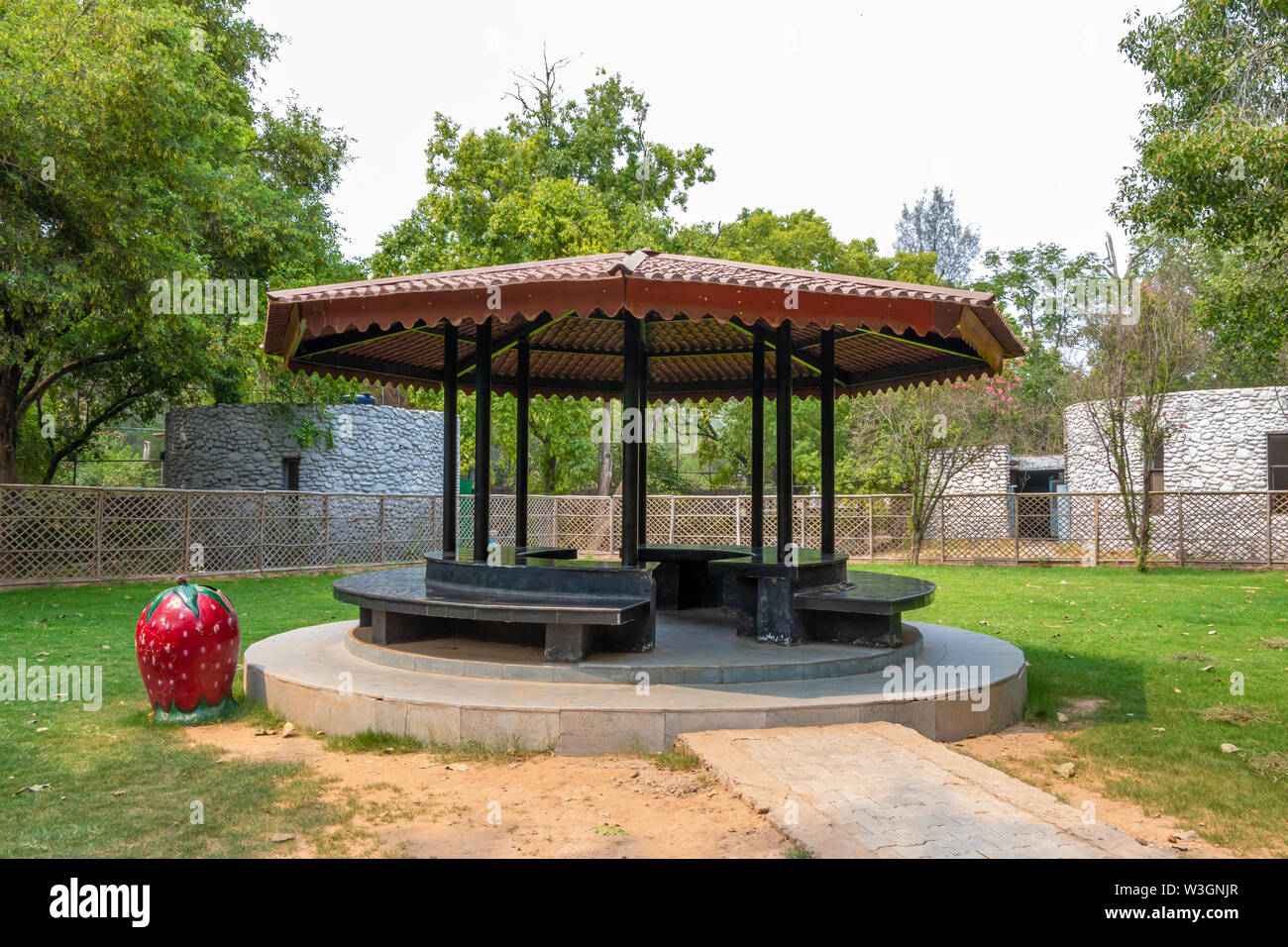 Steel structure shelter in a garden park with with benchs. place to spend time or rest. Stock Photo